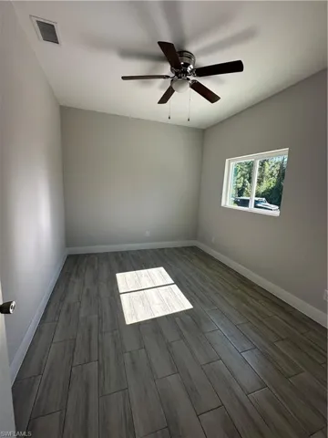 Spare room with hardwood / wood-style flooring and ceiling fan