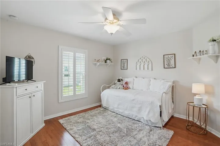 Bedroom featuring wood finished floors, baseboards, and a ceiling fan