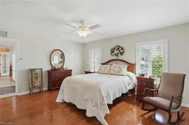 Bedroom with multiple windows, wood finished floors, and baseboards
