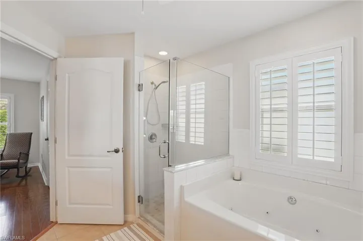 Bathroom with a shower stall and a whirlpool tub