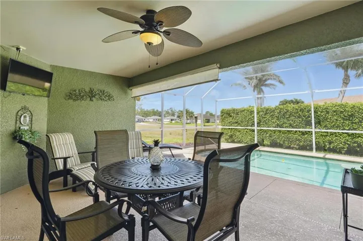 View of patio featuring glass enclosure and ceiling fan