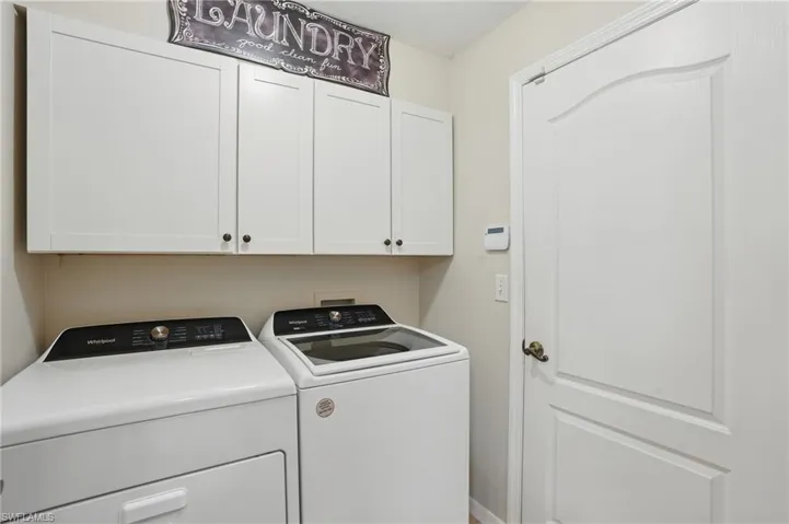 Washroom featuring cabinet space and washer and clothes dryer