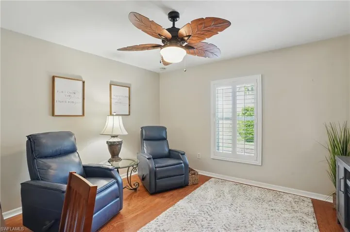 Living area featuring baseboards, a ceiling fan, and wood finished floors