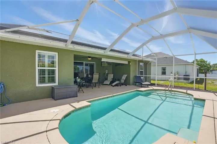 Swimming pool featuring a patio, a ceiling fan, and screened lanai
