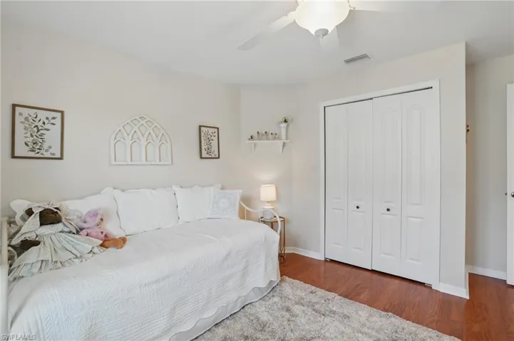 Bedroom with wood finished floors, a closet, baseboards, and ceiling fan