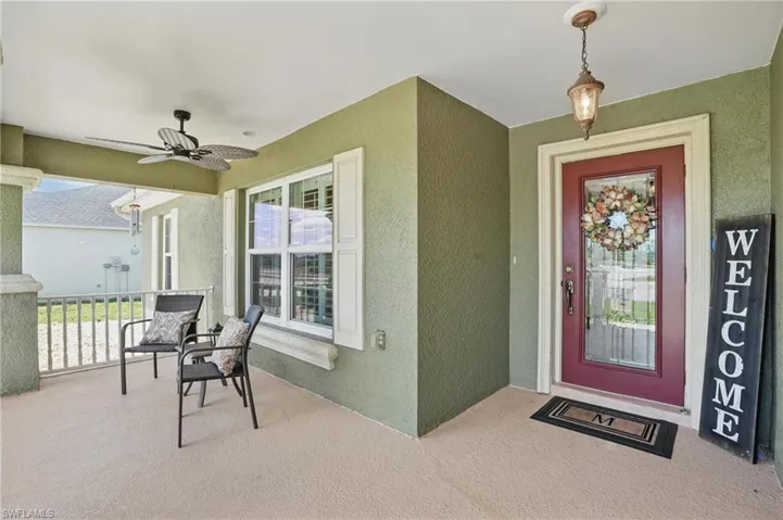 Property entrance featuring a ceiling fan, stucco siding, and covered porch
