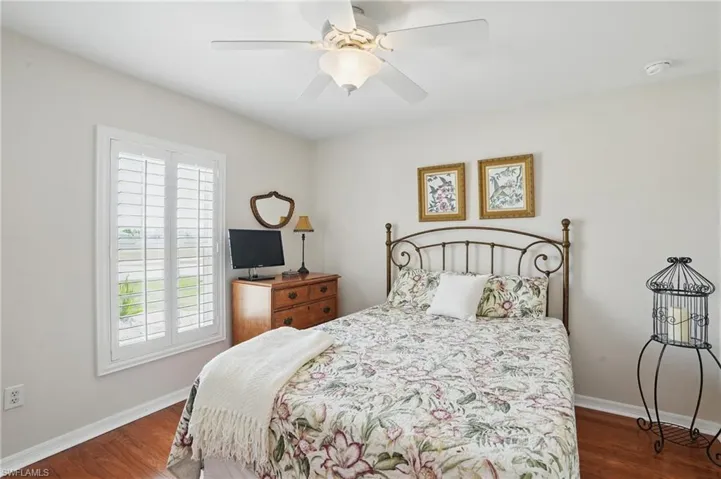 Bedroom with wood finished floors, baseboards, and ceiling fan