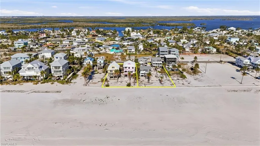 Beachfront property featuring direct sand access, multiple multi-story residences, and proximity to canals