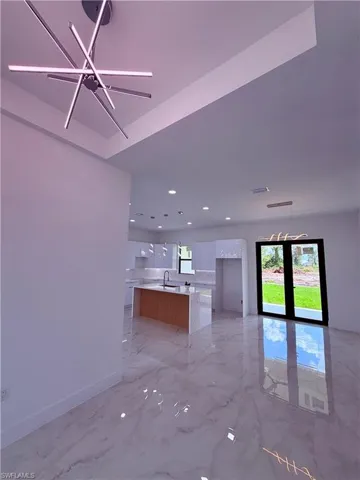 Spacious interior with polished marble-look flooring and a contemporary chandelier