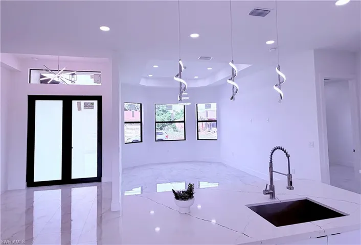Kitchen island featuring a dark basin sink and a contemporary pull-down faucet