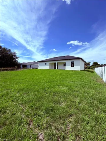 Expansive grassy yard with a white picket fence on one side