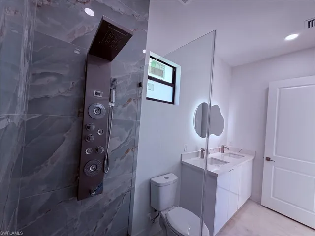 Shower with stone-finish tile surround and a multi-function panel