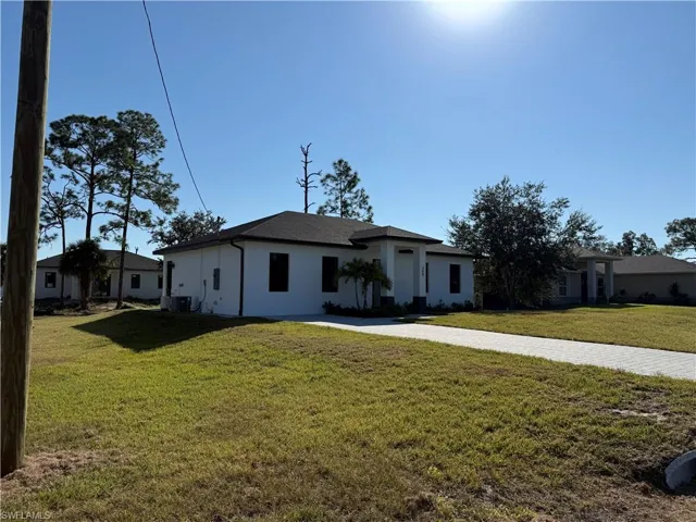 View of front of house featuring a front lawn and stucco siding