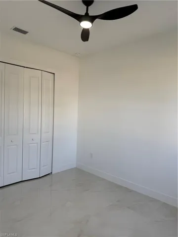 Unfurnished bedroom with a ceiling fan and a closet