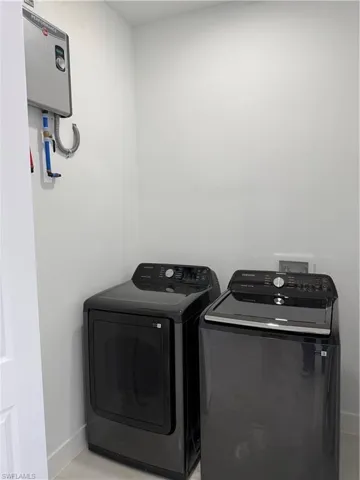 Washroom with washing machine and dryer and water heater