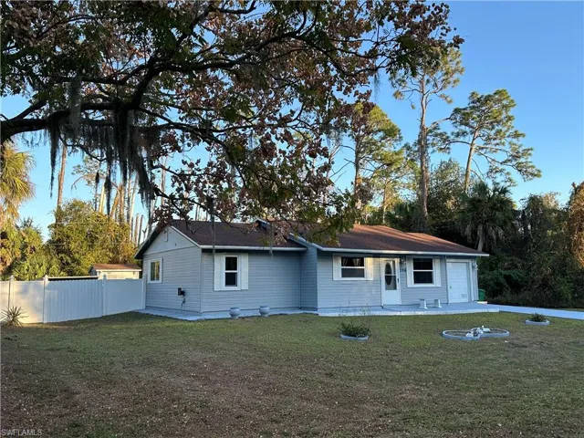 Rear view of property with a garage and a patio area