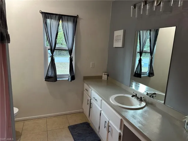 Half bath featuring vanity and light tile patterned flooring