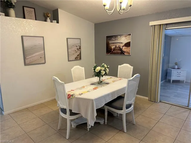 Dining area featuring light tile patterned floors and a chandelier