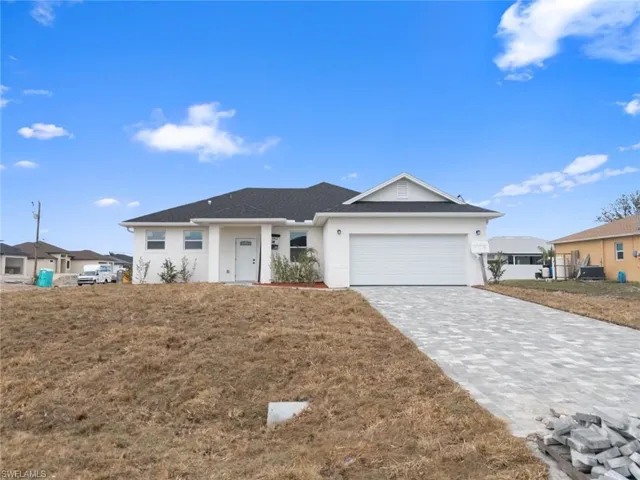Single story home featuring a front yard and a garage