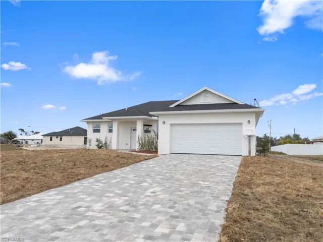View of front of house with a front lawn and a garage