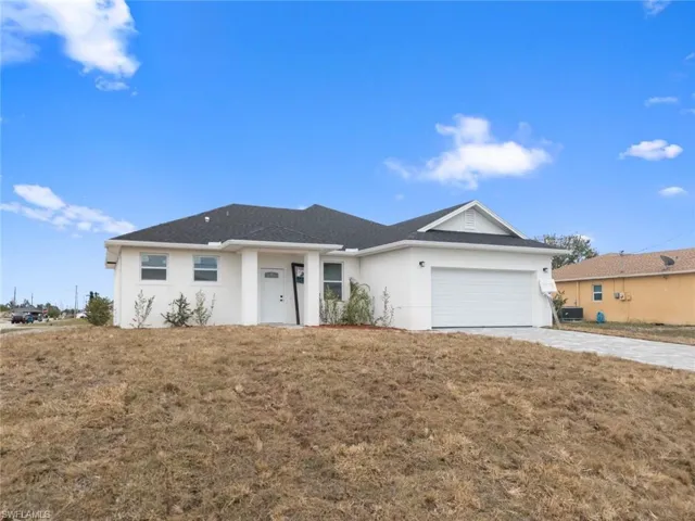 Ranch-style home with a front yard and a garage