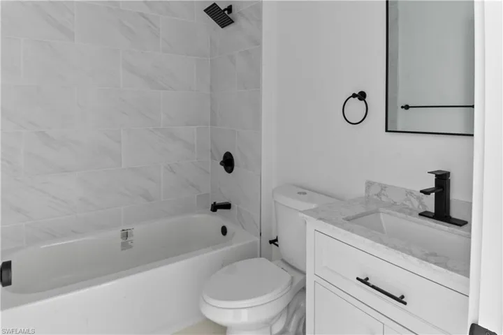 Full bathroom featuring toilet, vanity, and tiled shower / bath