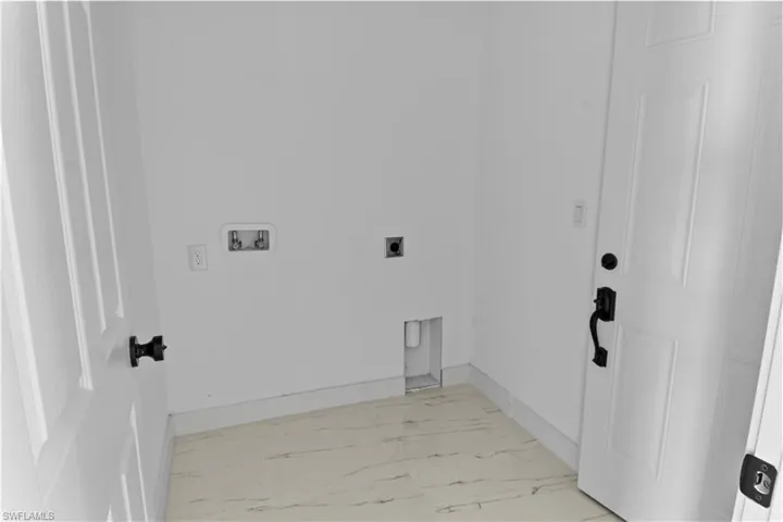 Clothes washing area featuring washer hookup and hookup for an electric dryer