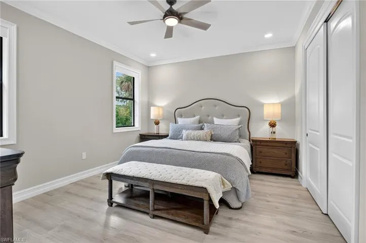 Bedroom with ornamental molding, a closet, light wood-style floors, recessed lighting, and a ceiling fan