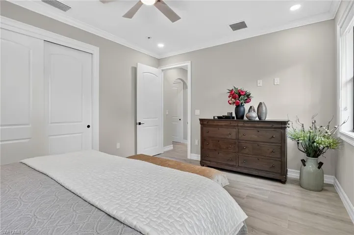 Bedroom with ornamental molding, light wood-style flooring, recessed lighting, a ceiling fan, and a closet