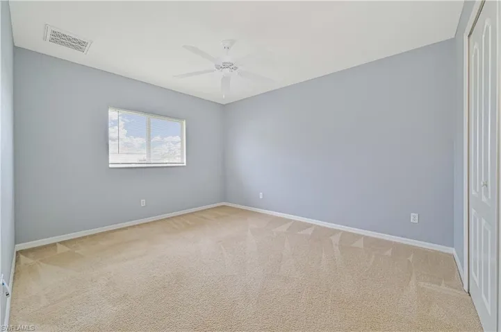 Carpeted spare room with ceiling fan