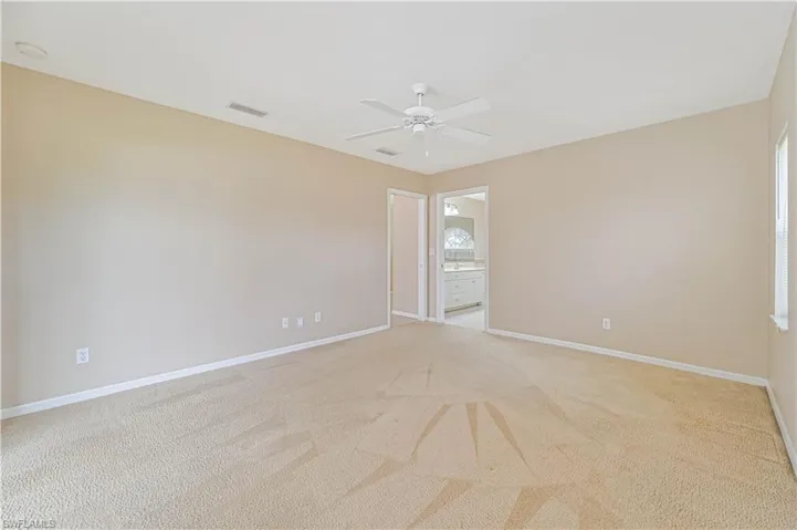 Unfurnished room with light colored carpet and ceiling fan