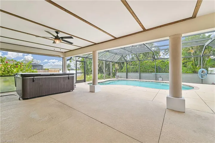 View of swimming pool with a patio area, ceiling fan, a lanai, and a hot tub
