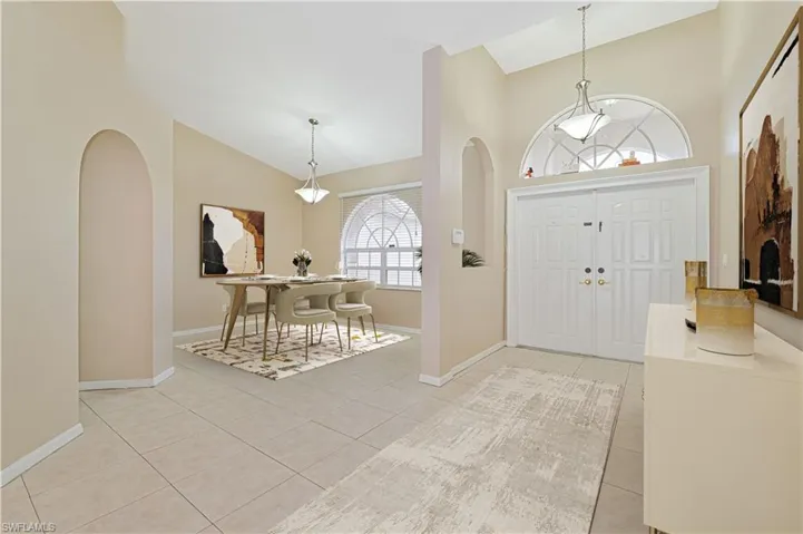 Tiled foyer with lofted ceiling