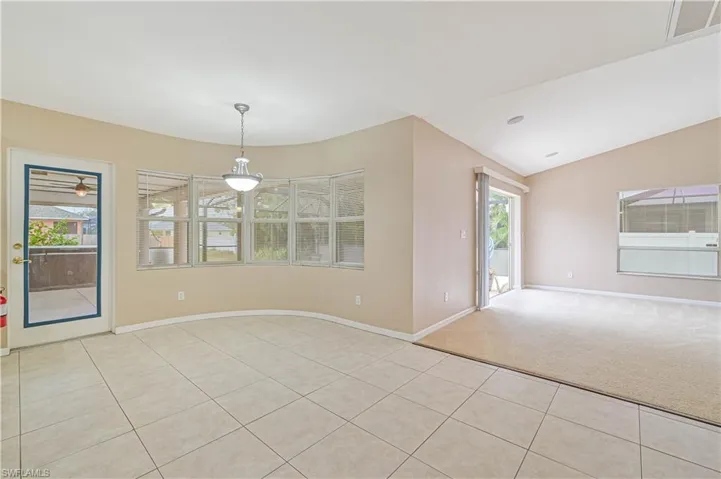 Spare room with light carpet and vaulted ceiling