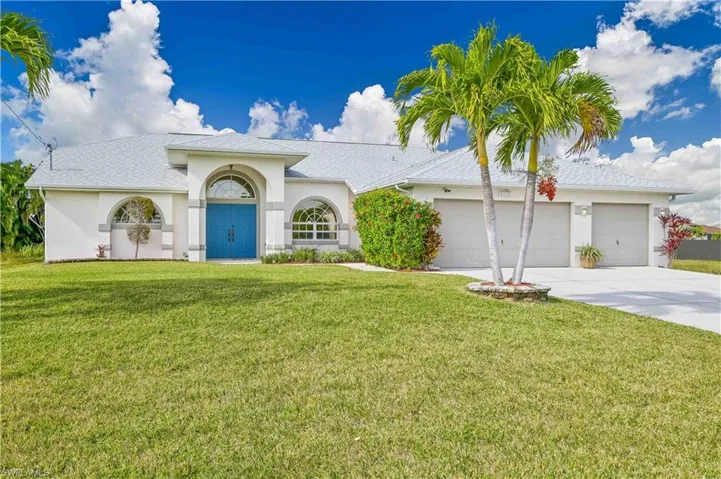 View of front of home with a garage and a front yard