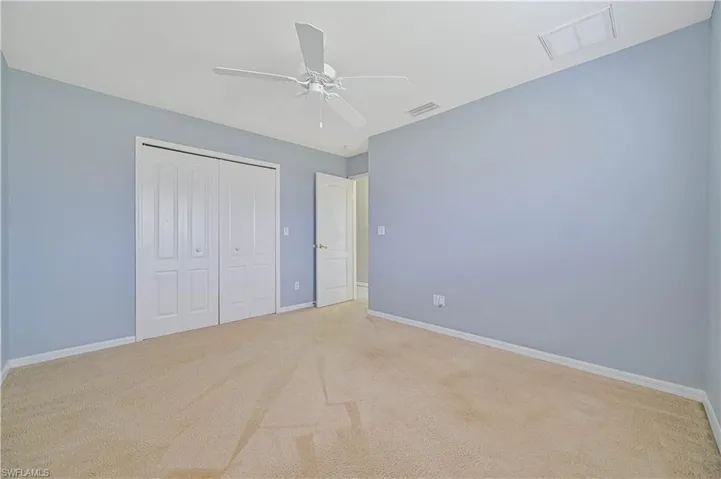 Unfurnished bedroom featuring light carpet, a closet, and ceiling fan