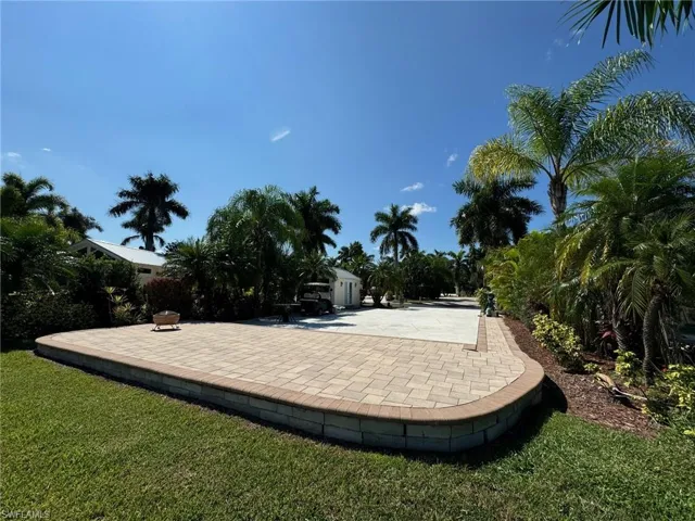 View of property's community featuring a lawn and a patio area