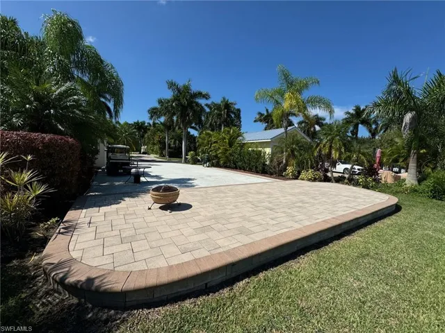 View of home's community featuring a patio area, an outdoor fire pit, and a yard