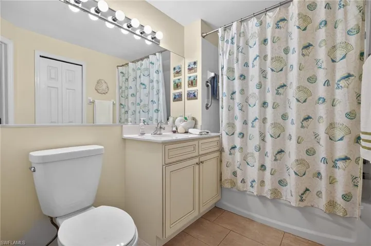 Full bath featuring vanity, light tile patterned flooring, and shower / bath combo