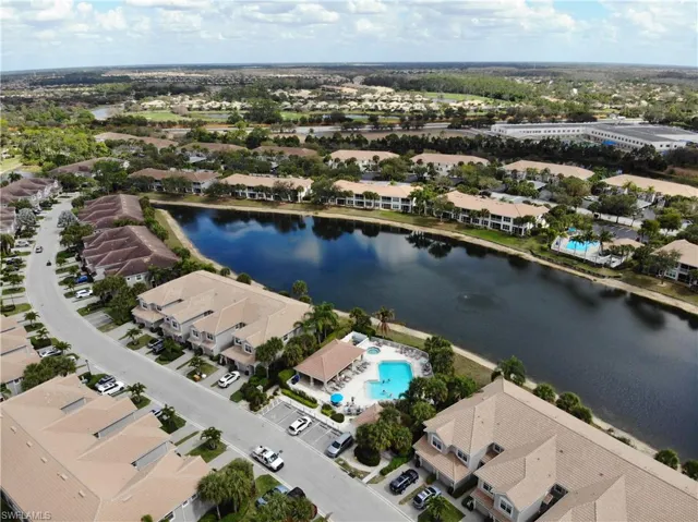 Aerial view of property and surrounding area with a nearby body of water and nearby suburban area