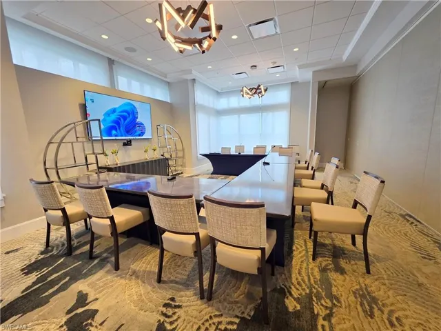 Dining area with hanging lights and a high ceiling