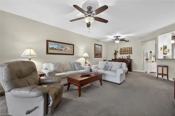 Carpeted living area featuring baseboards and a ceiling fan