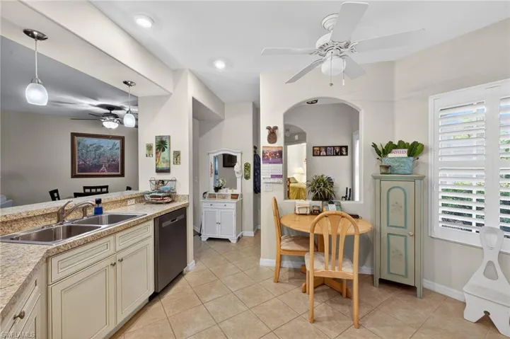 Kitchen featuring ceiling fan, light countertops, hanging light fixtures, dishwasher, and cream cabinets
