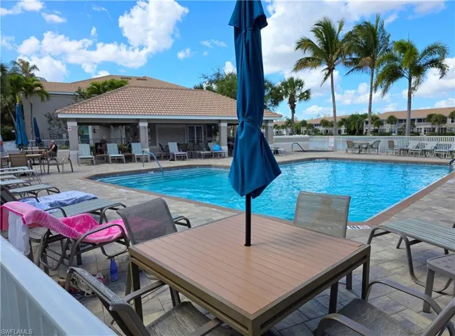 Community pool featuring a patio area and outdoor dining space