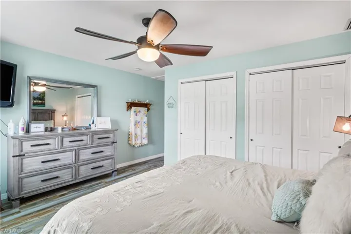 14937-Bedroom with dark wood-type flooring, two closets, and ceiling fan