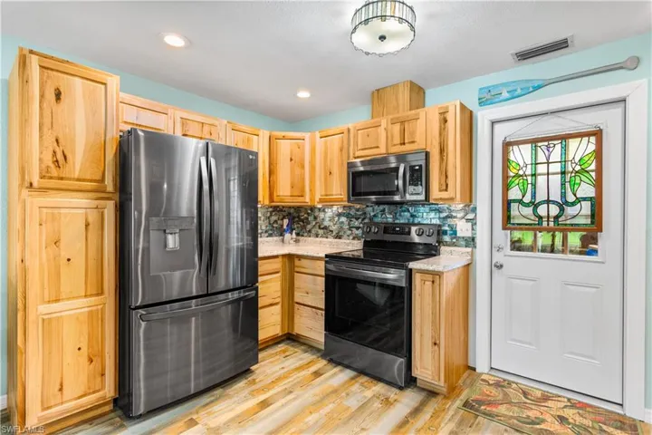 14937-Kitchen with light brown cabinetry, backsplash, appliances