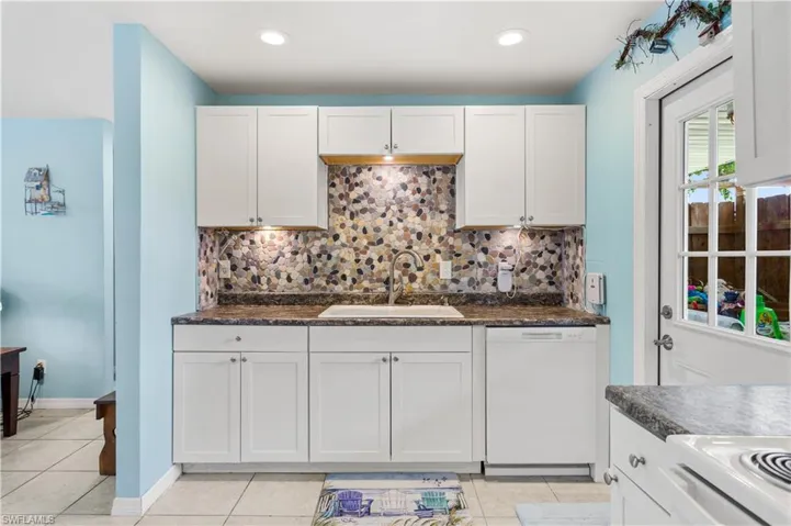 14939-Kitchen featuring sink, white cabinets, dishwasher, and tasteful backsplash