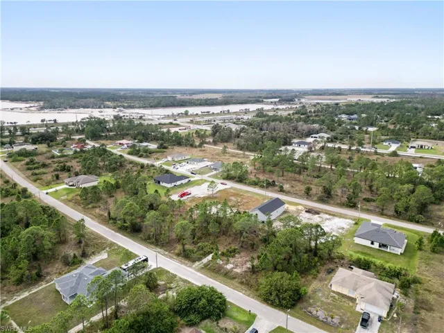 Aerial perspective showcasing a residential area with multiple single-story homes and undeveloped plots