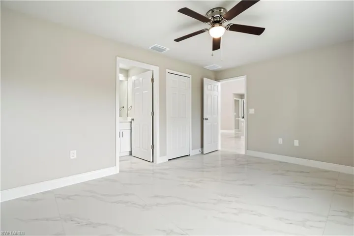 Spacious room featuring large format tile flooring, a ceiling fan with integrated lighting, neutral wall paint, and white baseboards