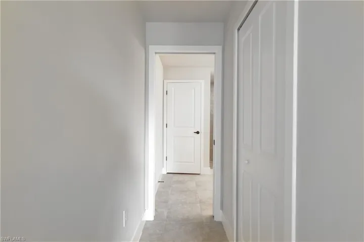 Hallway featuring light tile patterned floors